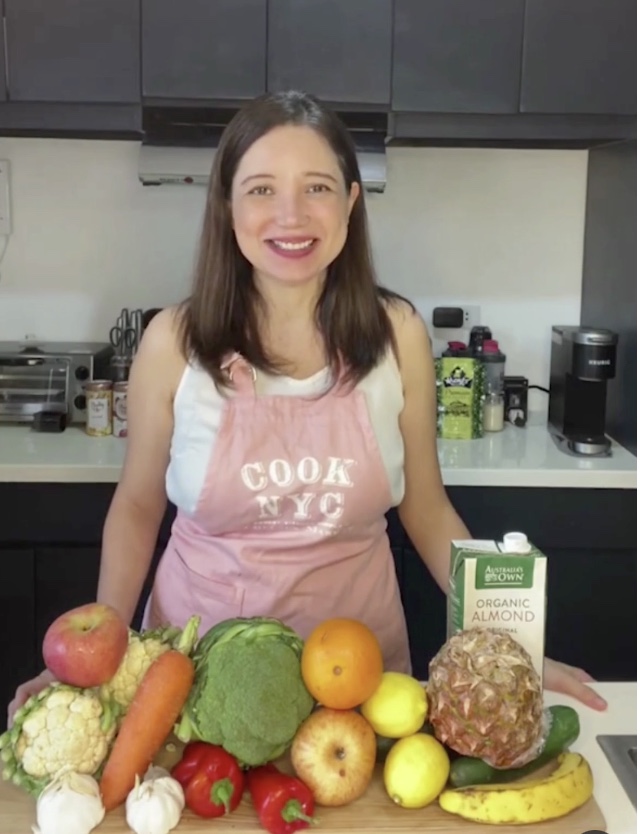 Coach Chelie in her kitchen with fresh fruit and vegetables